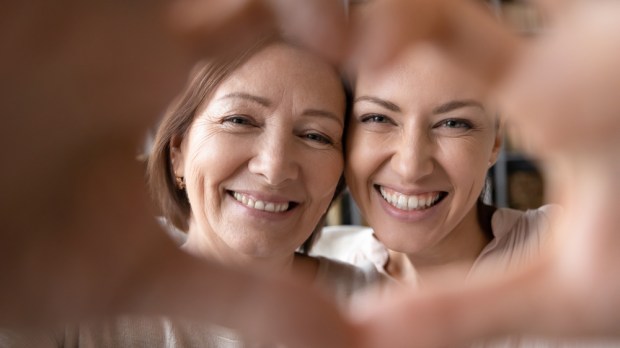 mama z dorosłą córką spędzają ze sobą dobry czas i układają dłonie w kształt serca