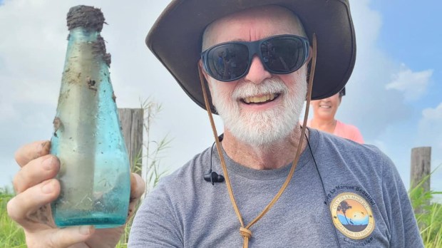 Terry-Pettijohn-with-the-note-in-a-bottle-he-found-while-cleaning-up-trash-along-a-bayou-in-La-Marque