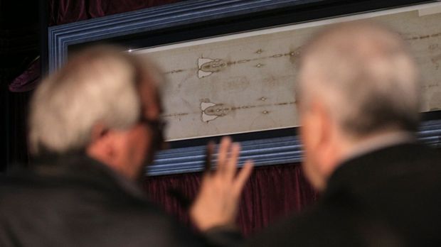 Dwóch mężczyzn ogląda Całun Turyński