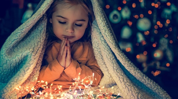 dziewczynka modli się w oczekiwaniu na Boże Narodzenie