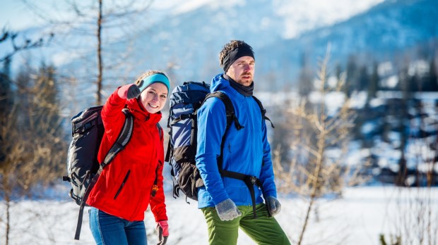 Para młodych ludzi wędruje zimą po górach